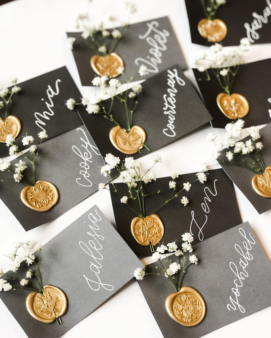 Fresh flowers on black place cards with white calligraphy